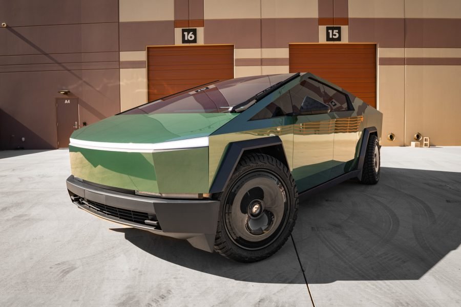 Tesla Cybertruck parked in front of industrial garage doors, showcasing its angular design and futuristic stainless-steel exterior, highlighting its unique features as a rental option in Scottsdale and Phoenix.