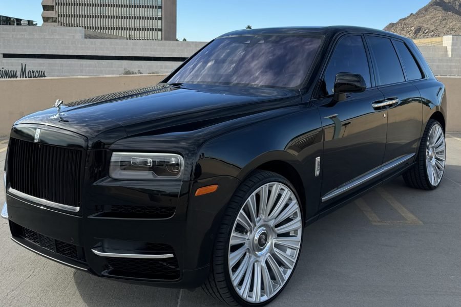 Black Rolls-Royce Cullinan luxury SUV with distinctive grille and Spirit of Ecstasy emblem, parked in urban setting, showcasing elegant design and premium wheels, ideal for Scottsdale and Phoenix rentals.