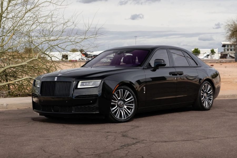 Rolls-Royce Ghost luxury sedan parked on a desert road, showcasing its sleek black exterior, iconic grille, and elegant design elements, ideal for rentals in Scottsdale and Phoenix.